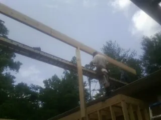 Carpenter setting a ridge beam over a new addition frame — Ice Dam Removal by Roofing Brothers in West Oneonta