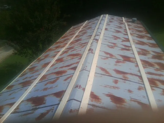 Rusted metal roof panels with new wood purlins before replacement — Storm Damage Roof Repair in West Oneonta by Roofing Brothers