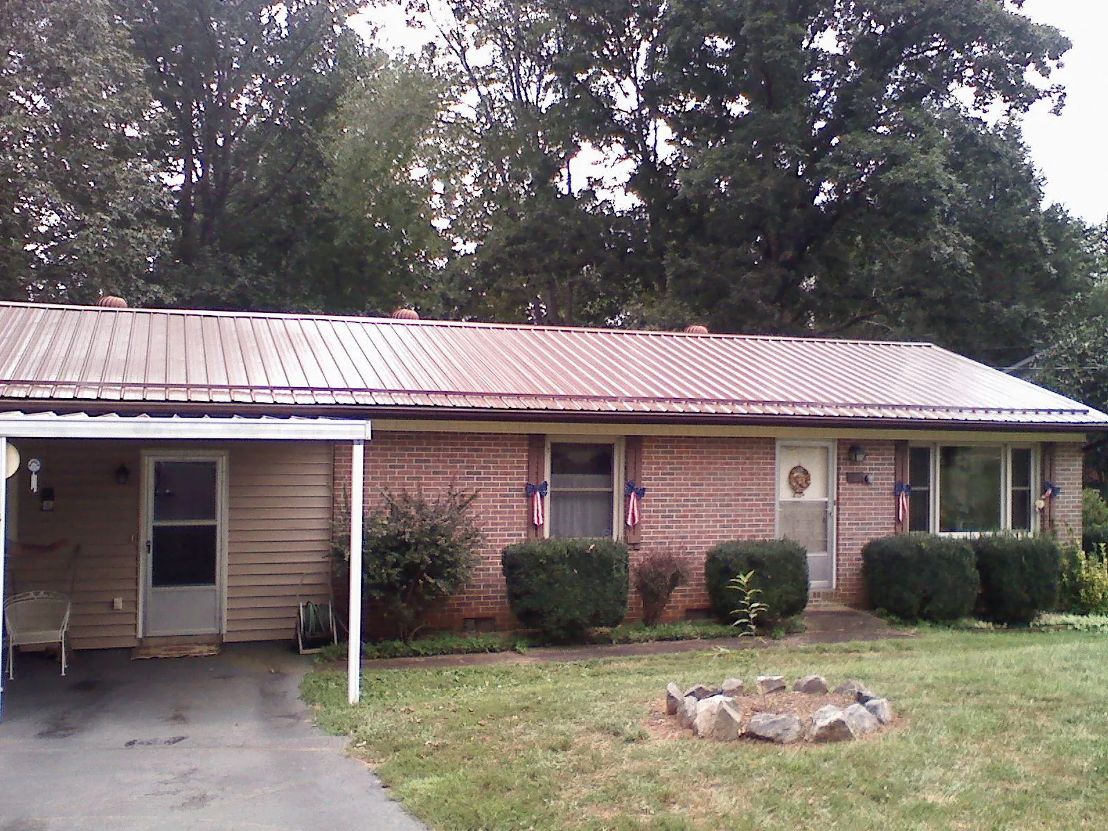 Bronze metal roof and carport on a brick ranch home — Roof Repair work by our crew in West Oneonta
